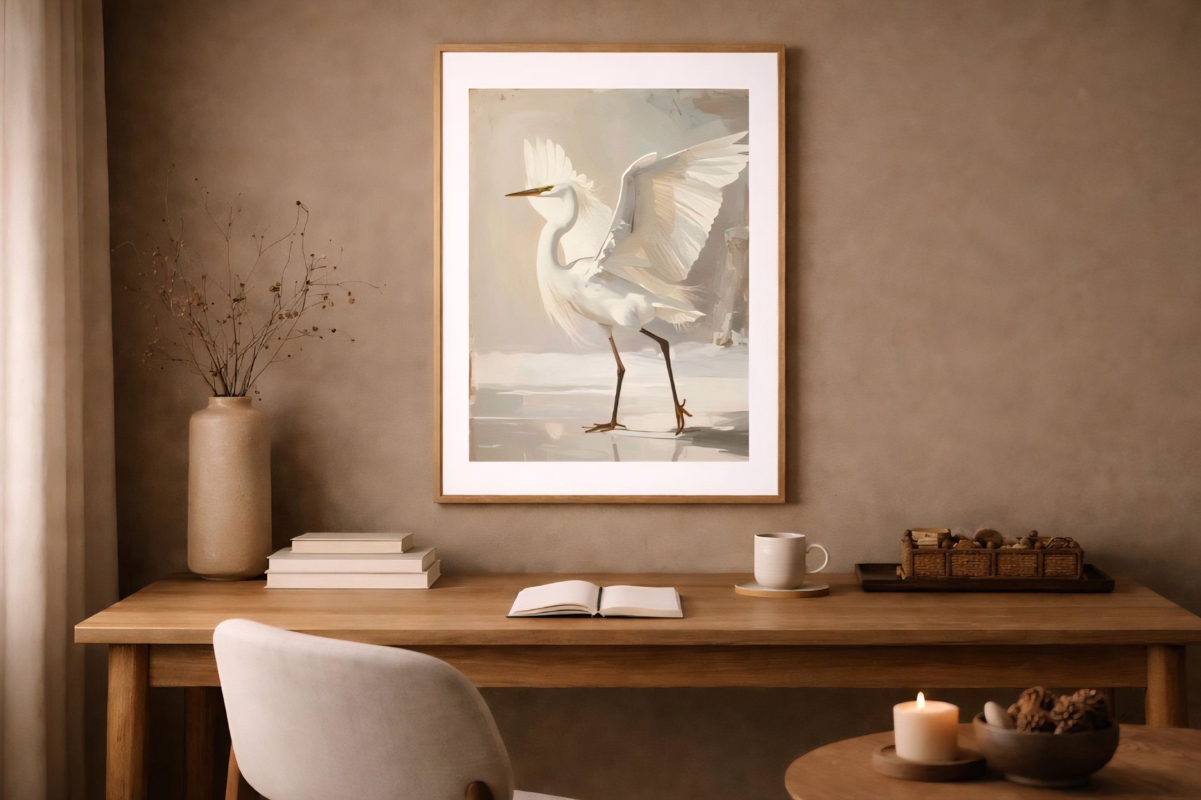 White egret digital download wall art in light wood frame above modern desk, warm neutral workspace with ceramics, books, and soft ambient lighting.