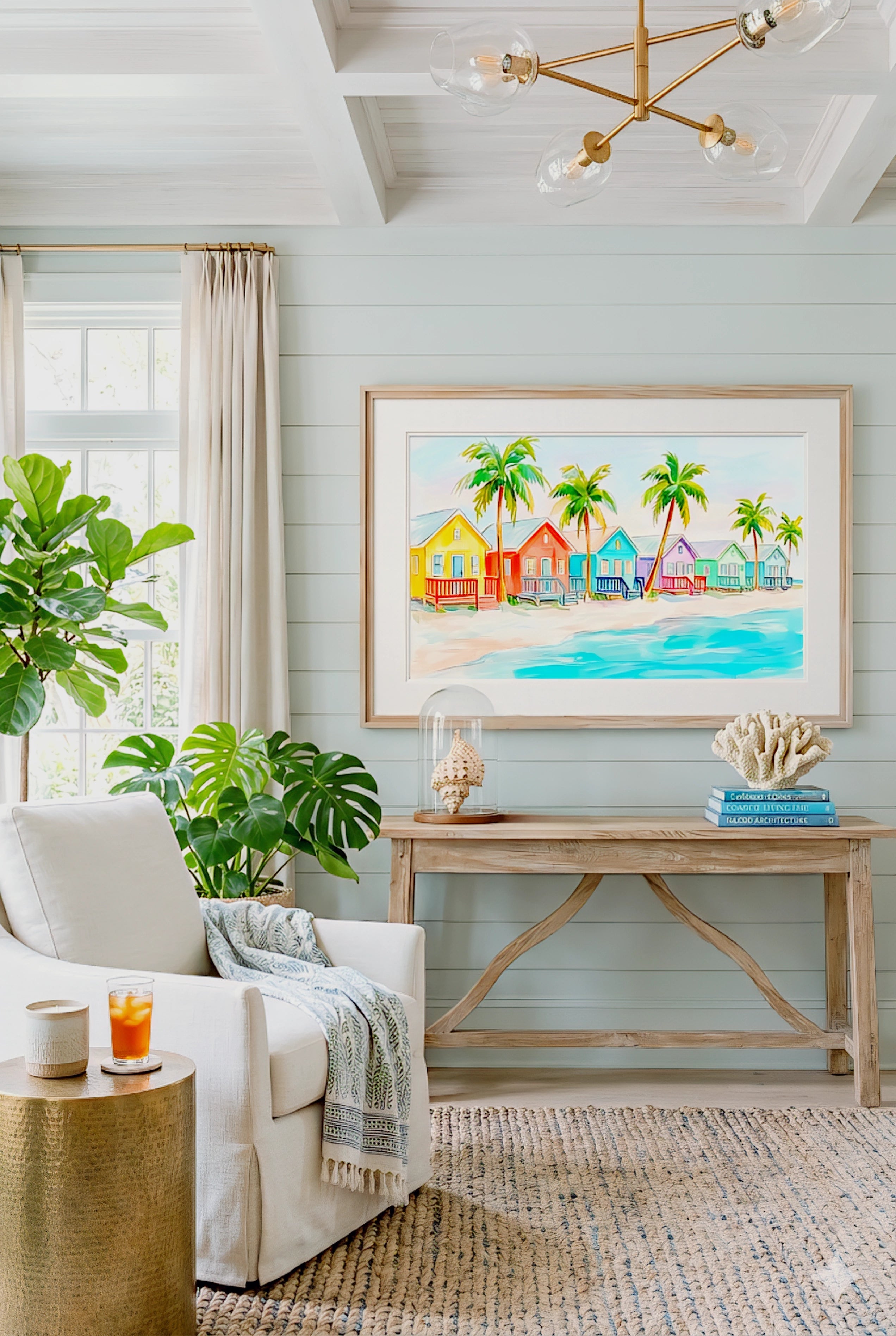 Colorful beach houses wall art in bright coastal living room, tropical palm tree ocean print framed above console for modern beach home decor