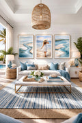 Coastal wall art set of 3 prints styled in a bright living room, ocean abstract artwork and beach scene decorinspo for beach house or modern coastal home decor