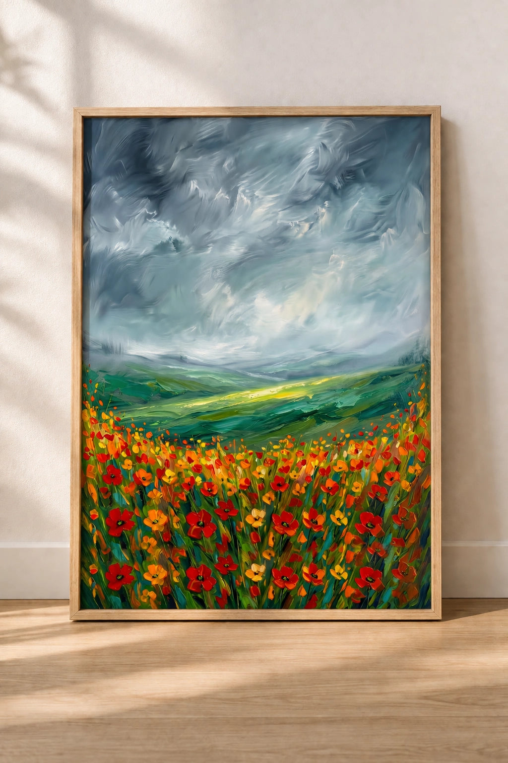 Stormy poppy field wall art in oak frame leaning against wall, bold landscape printable decor