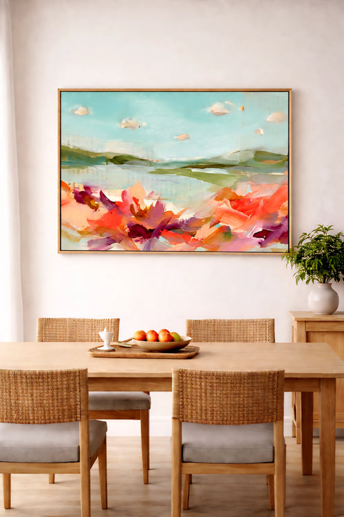 Savvy places large abstract coastal landscape wall art in aqua and coral tones above dining table, modern printable art in light wood frame styled in warm neutral dining room decor