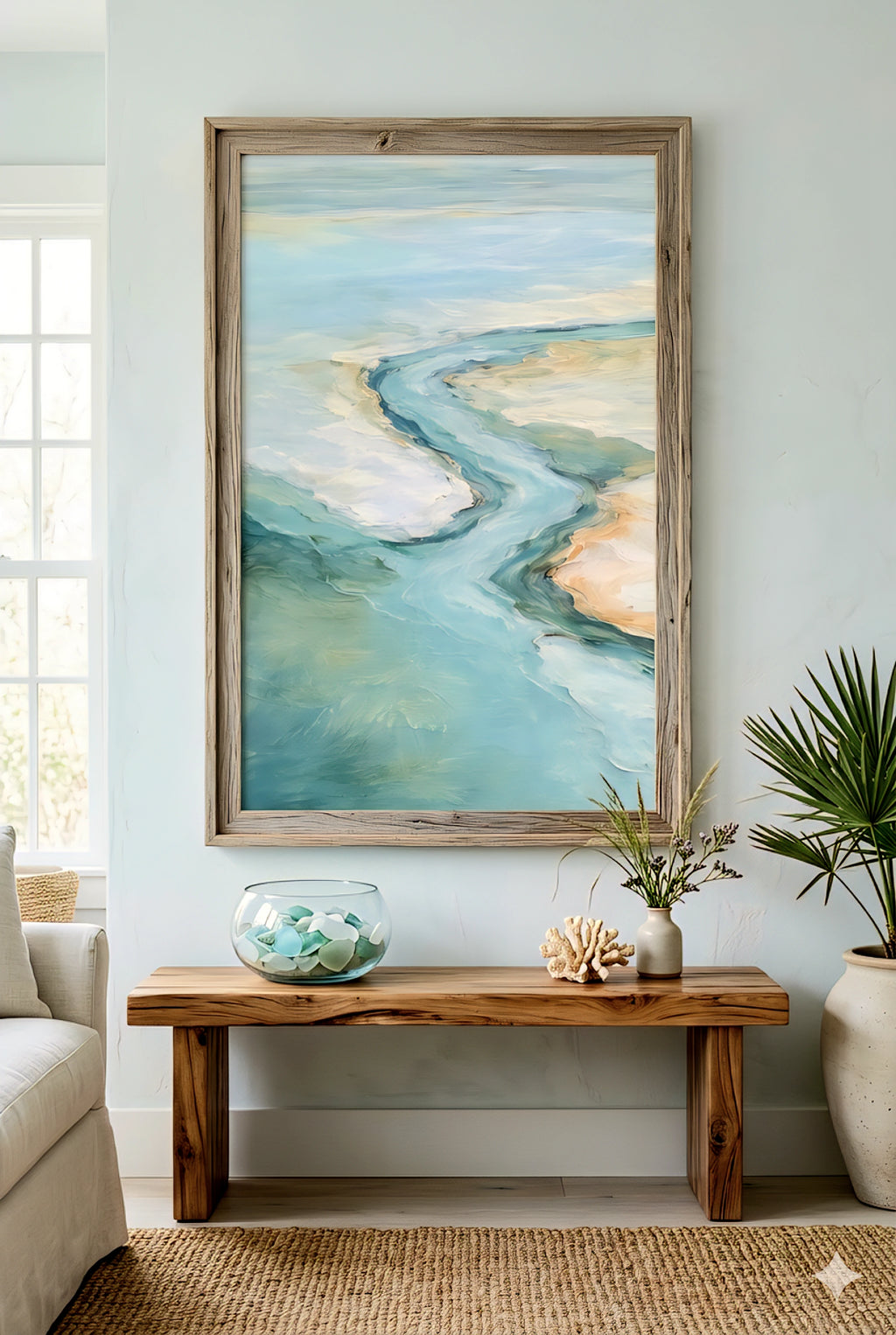 Large coastal ocean artwork above wooden bench with glass bowl, coral decor and soft neutral beach style room