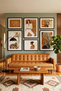 Earth tone safari gallery wall set of 6 above tan leather sofa with giraffe, elephant, abstract and portrait prints in modern living room