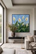 Savvy places framed peace lily wall art with white blooms and lush green leaves on a soft blue background displayed in a modern neutral living room, botanical printable decor digital download