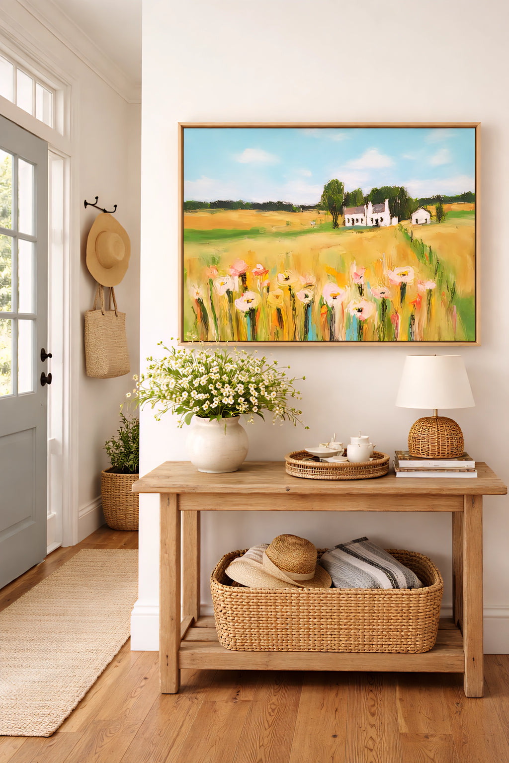 Farmhouse entryway with large landscape wall art above wooden console table with woven baskets and soft neutral decor