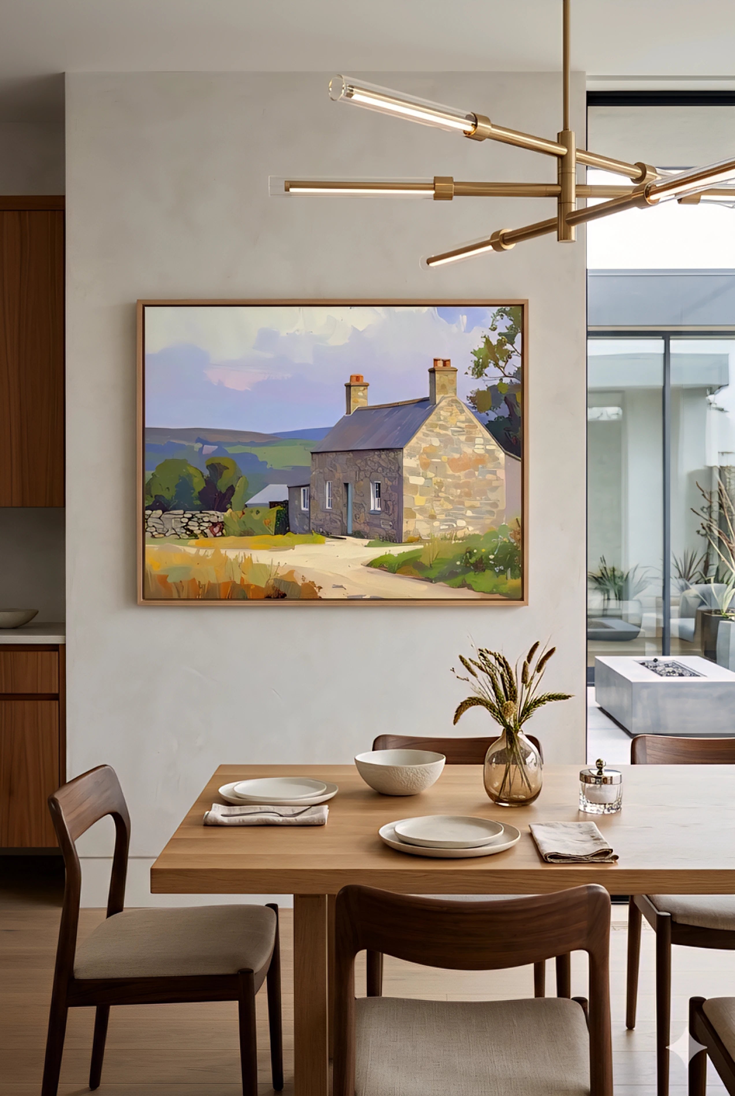 Scottish cottage wall art in dining room, horizontal landscape painting of stone house and countryside, warm modern decor with wood table, large printable wall art for kitchen or dining space