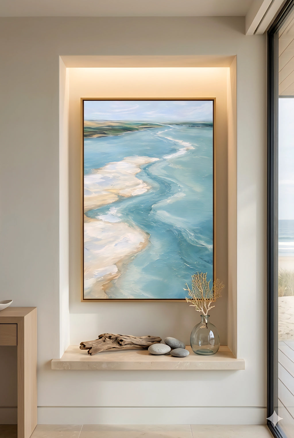 Coastal ocean artwork in recessed wall niche with shelf decor, driftwood and glass vase in modern beach home