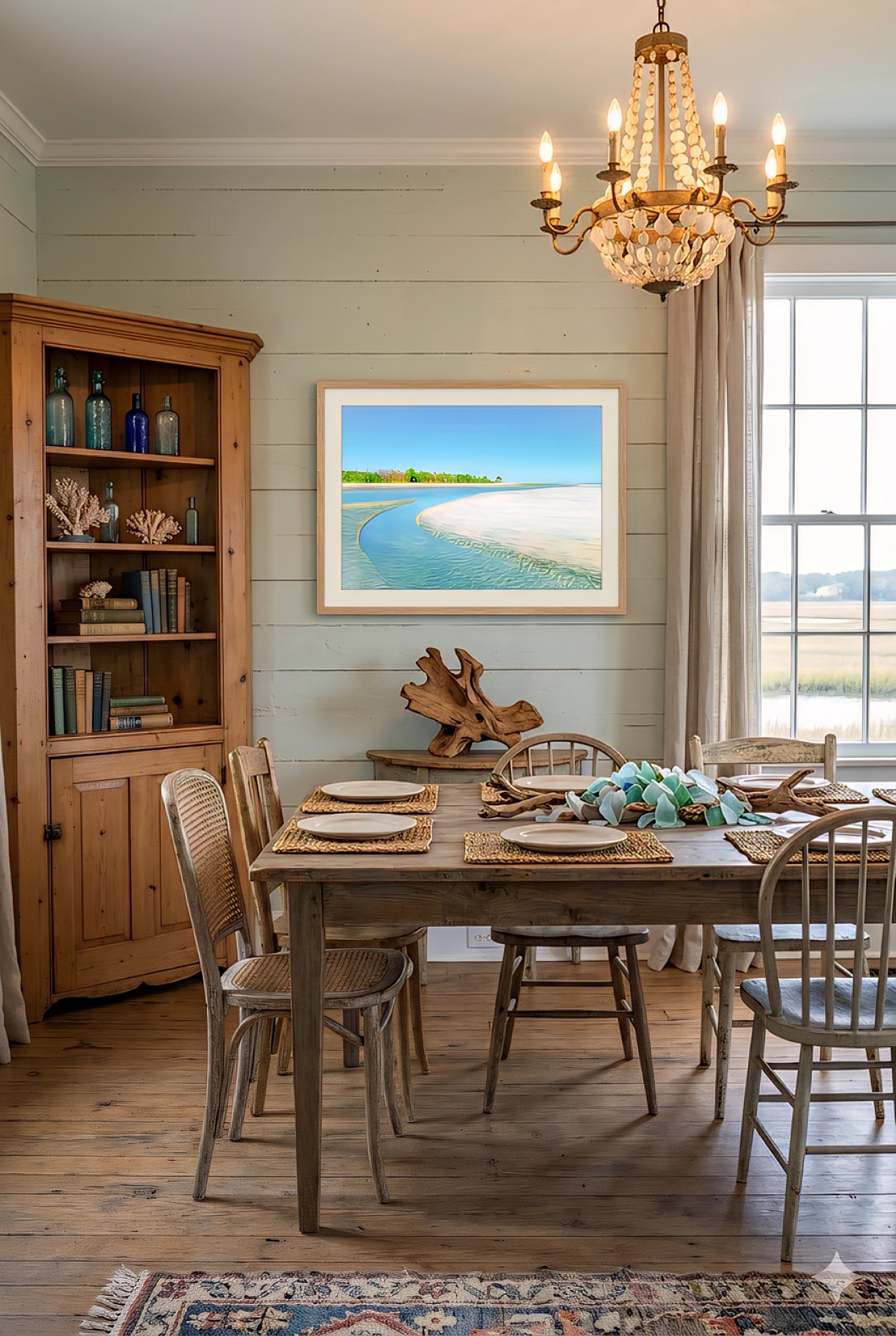 Coastal beach wall art in rustic dining room with wood table, vintage chairs, chandelier, and soft green shiplap walls, featuring a turquoise shoreline print for relaxed coastal decor