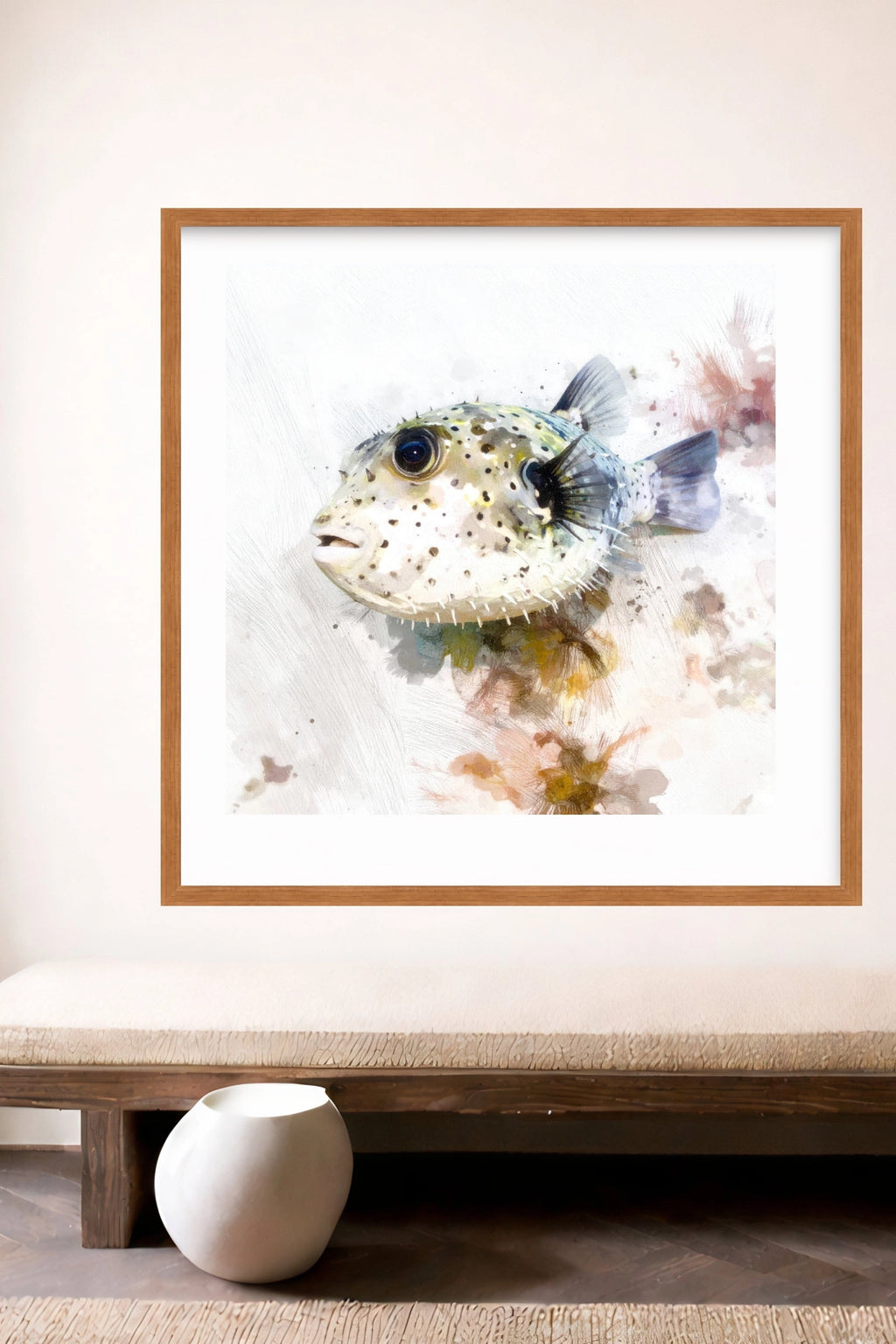Framed digital artwork of a puffer fish on a white wall above a wooden bench.